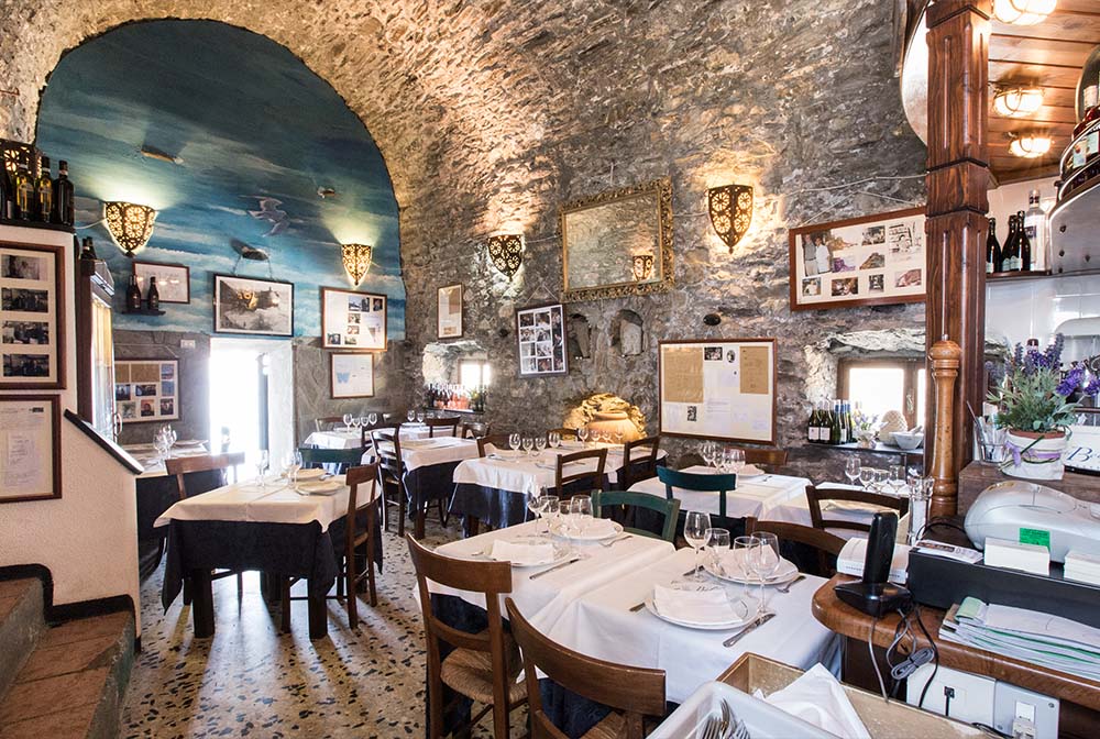 sala interna ristorante belforte a vernazza con muri in pietra